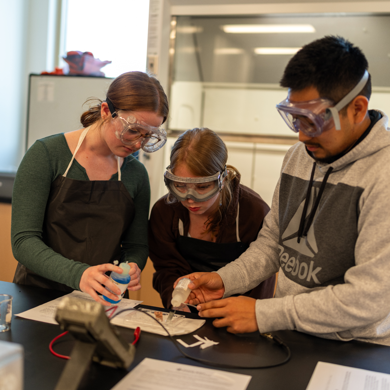 three students working together in chemistry lab